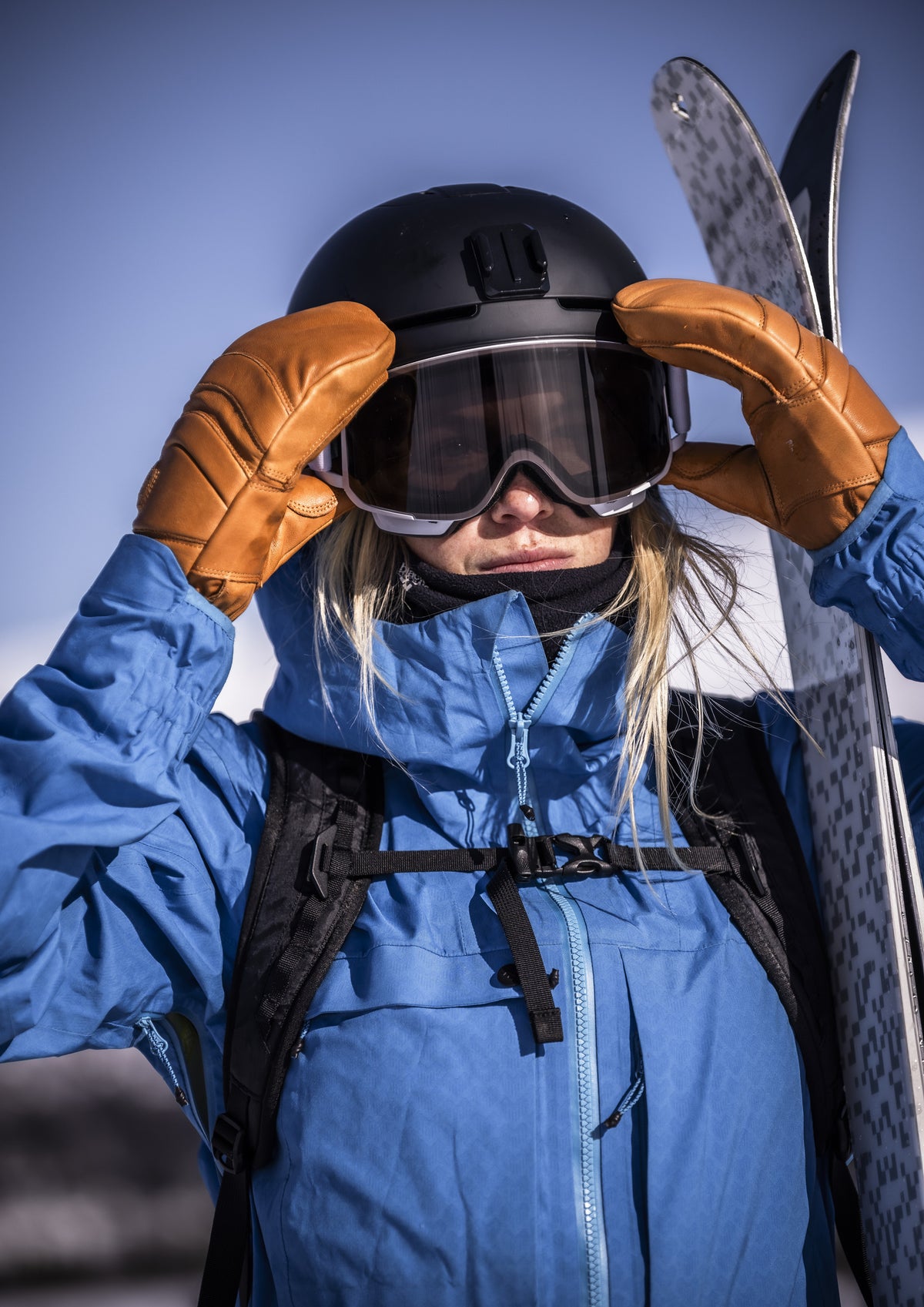 Skier wearing Hestra Fall Line Cork/Cork gloves adjusting helmet. Photo: HESTRA