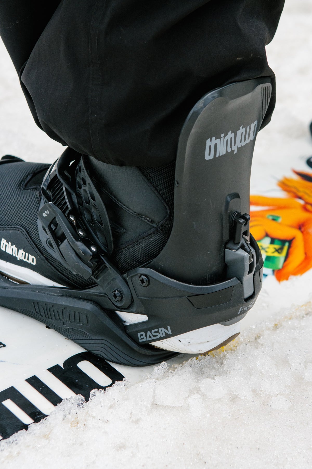 Close view of ThirtyTwo Basin FASE Black bindings with a rider strapped in