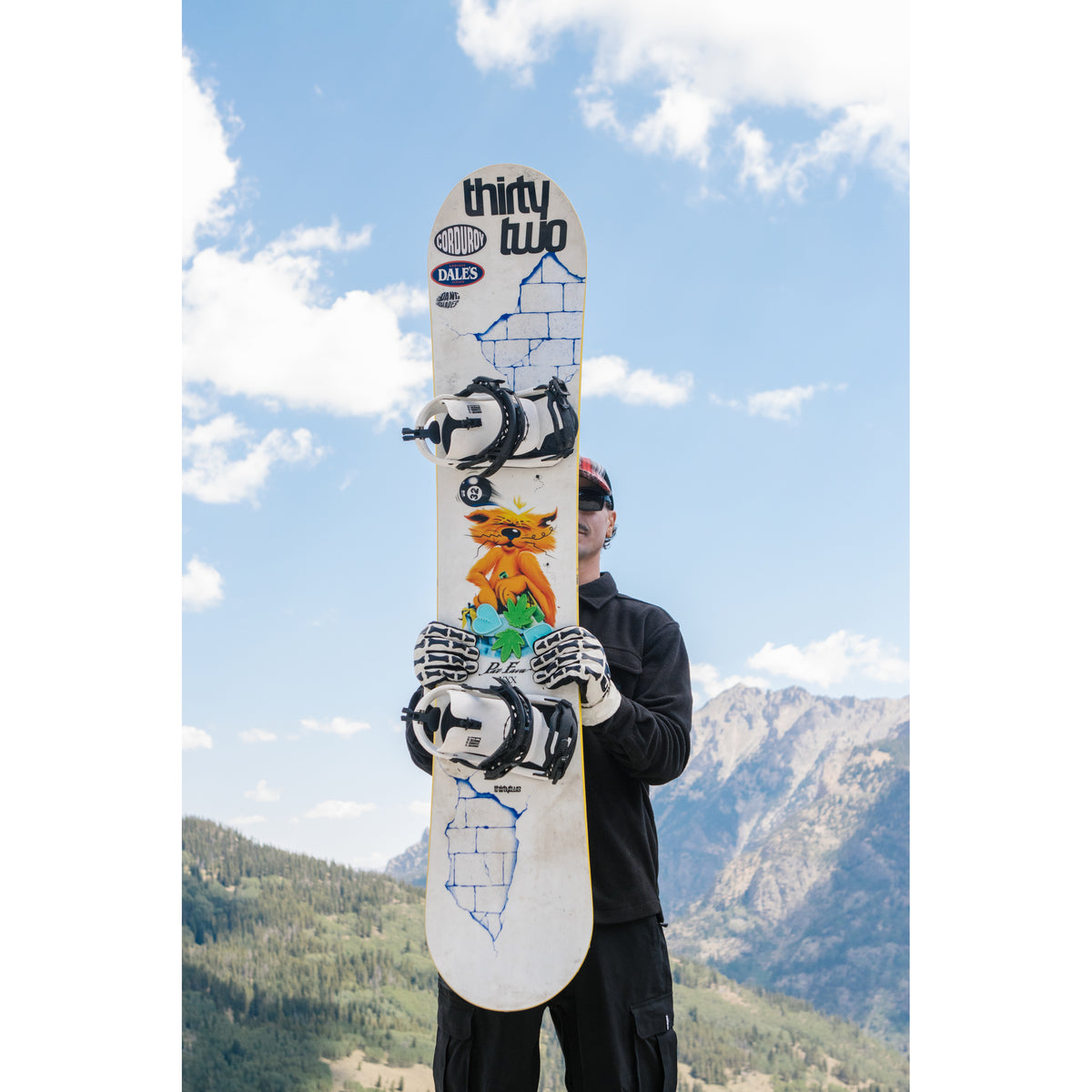 Pat Fava holding his XXX Fava Pro snowboard outdoors